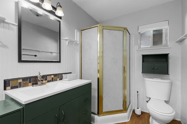 bathroom featuring a shower with door, hardwood / wood-style flooring, toilet, vaulted ceiling, and vanity