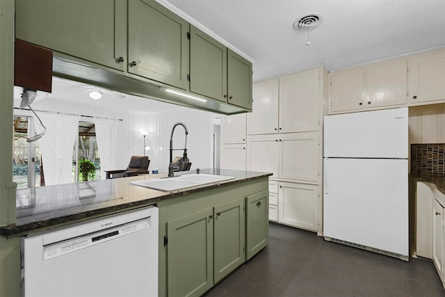 kitchen featuring white appliances, dark stone counters, green cabinetry, and sink