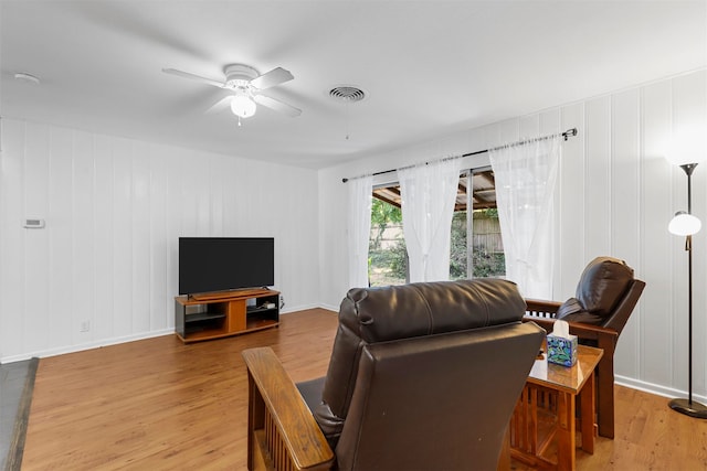 living room with ceiling fan and light hardwood / wood-style flooring