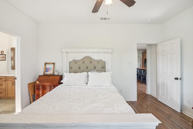 bedroom with hardwood / wood-style flooring, ensuite bath, and ceiling fan