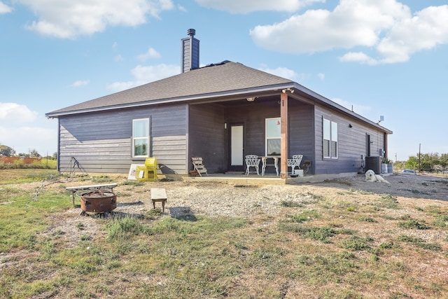 back of house with a fire pit, a patio area, and central air condition unit