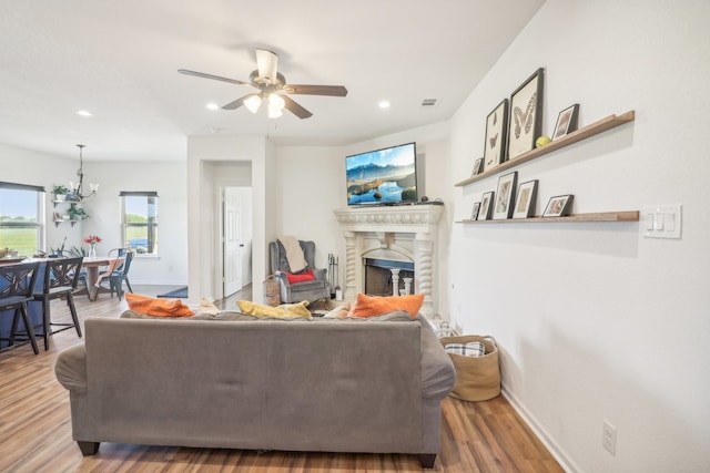 living room featuring hardwood / wood-style floors and ceiling fan with notable chandelier