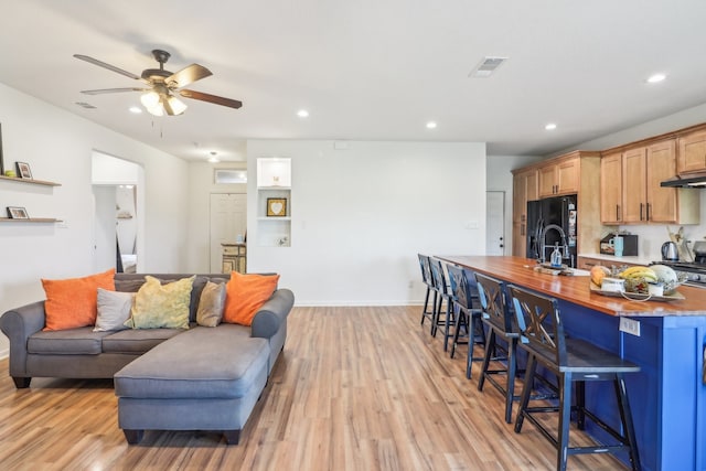 living room featuring ceiling fan and light wood-type flooring