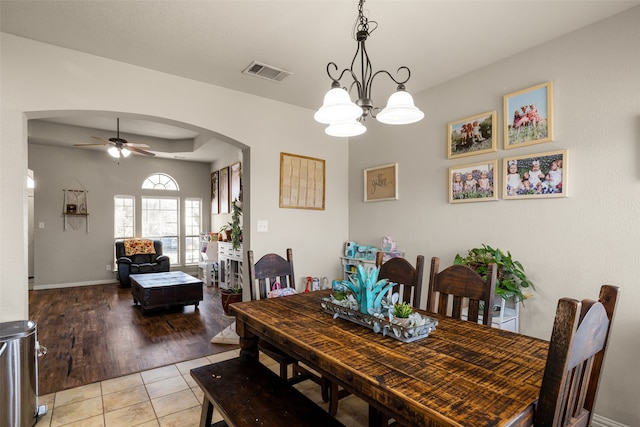 dining area with ceiling fan with notable chandelier and light wood-type flooring