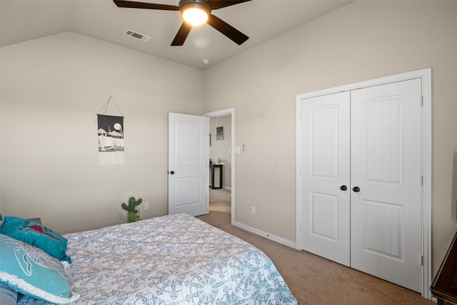 bedroom with vaulted ceiling, ceiling fan, a closet, and carpet