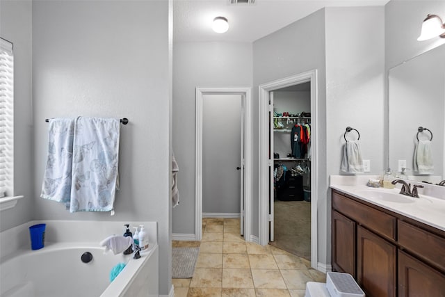 bathroom featuring vanity, a tub to relax in, and tile patterned flooring