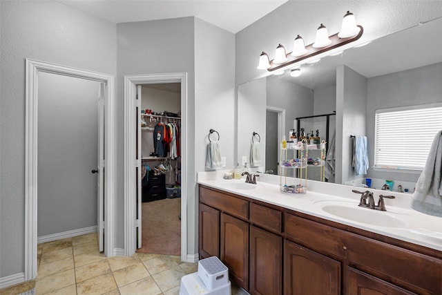 bathroom featuring tile patterned flooring, a shower with door, and vanity