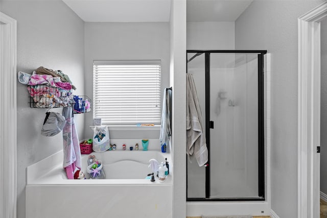 bathroom featuring independent shower and bath