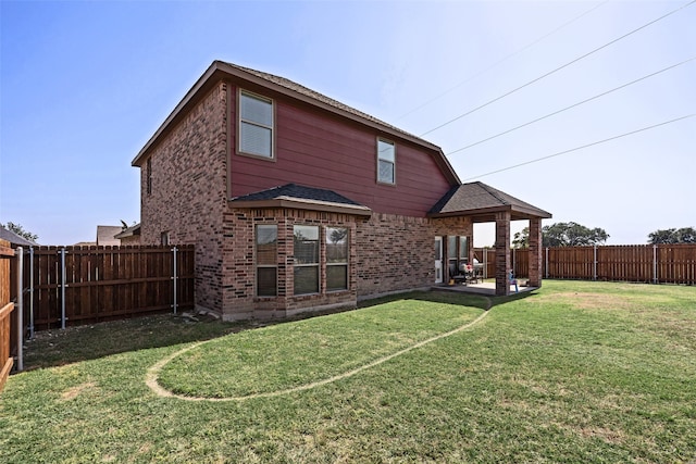 rear view of house with a lawn and a patio area