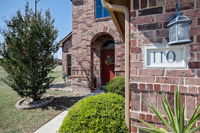 view of exterior entry with a yard