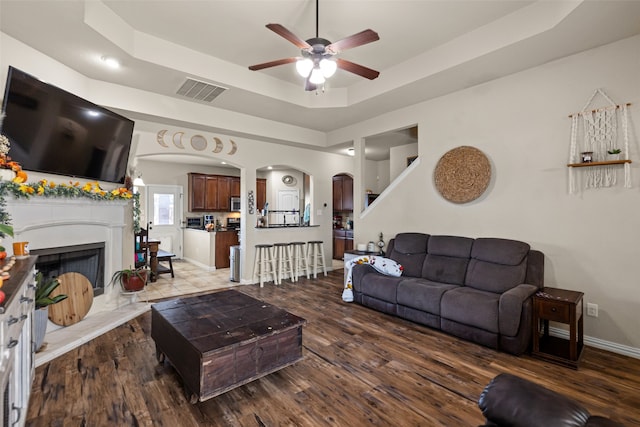 living room with hardwood / wood-style flooring and a raised ceiling