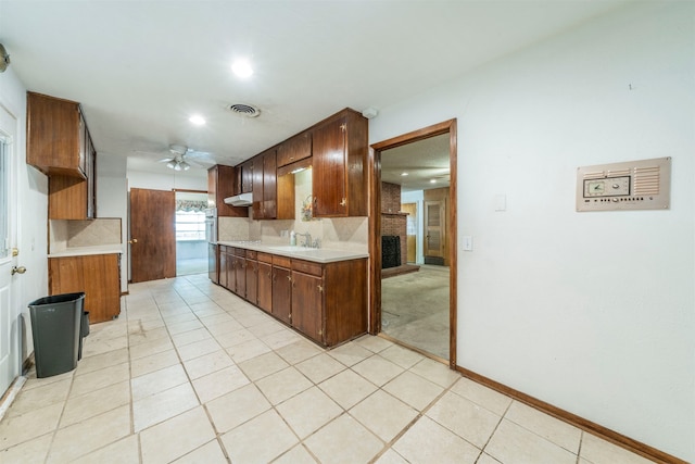 kitchen featuring decorative backsplash, sink, light tile patterned floors, and ceiling fan