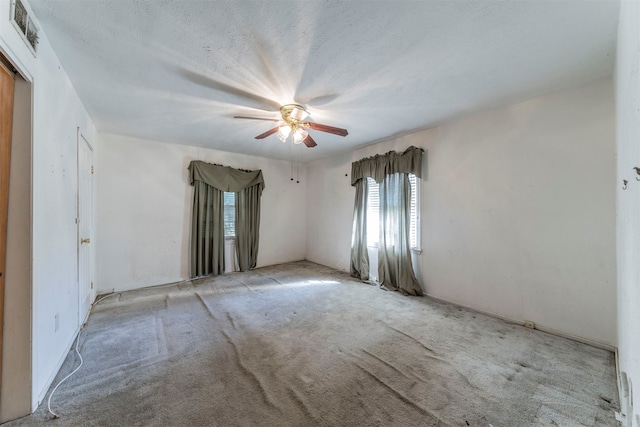 spare room with light carpet, a textured ceiling, and ceiling fan