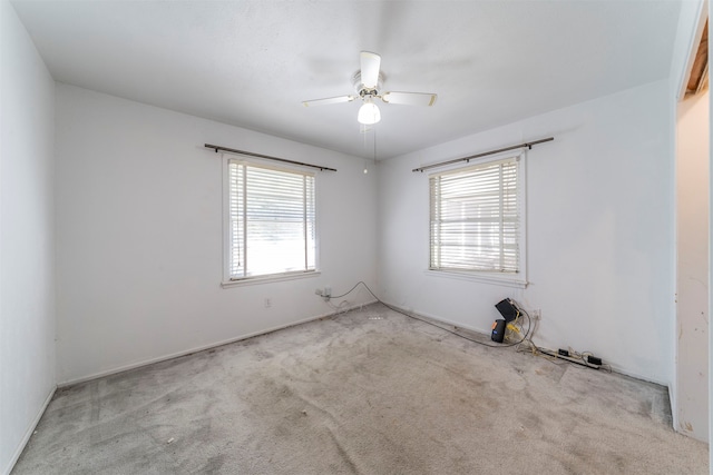 carpeted spare room featuring ceiling fan and a wealth of natural light