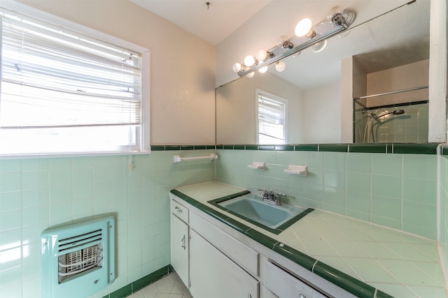 bathroom featuring vanity, heating unit, plenty of natural light, and tile patterned flooring