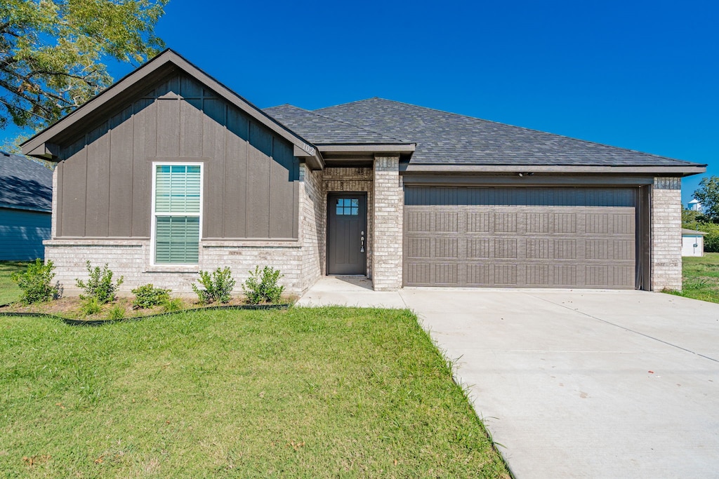 view of front facade with a garage and a front lawn