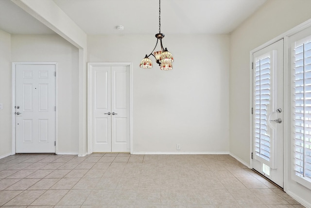 entrance foyer featuring light tile patterned flooring, a chandelier, and a wealth of natural light