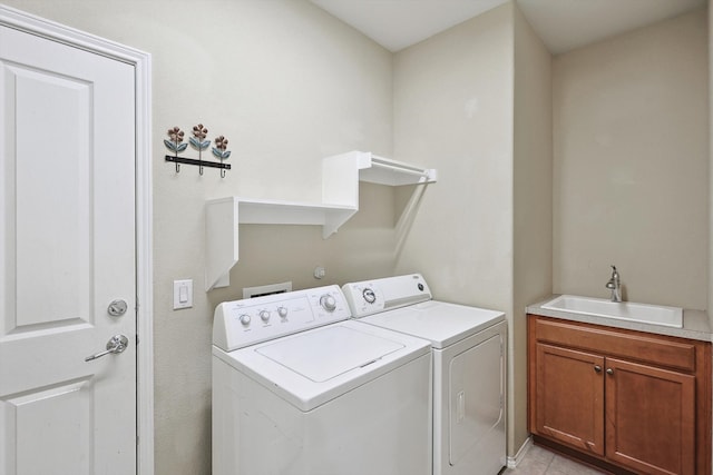 laundry room with washer and clothes dryer, cabinets, sink, and light tile patterned flooring