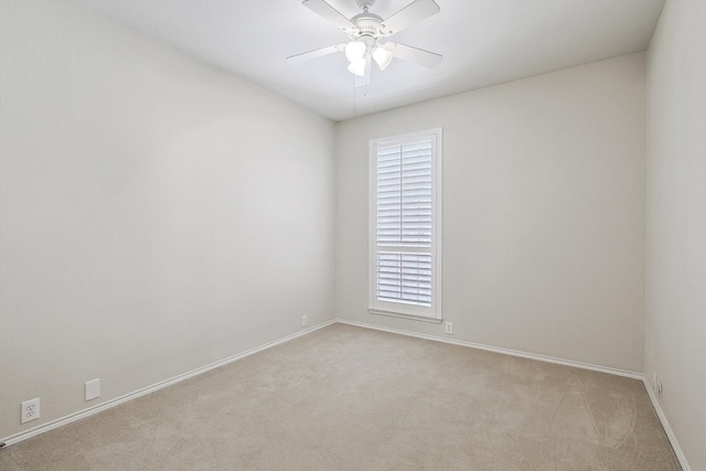 carpeted spare room featuring ceiling fan