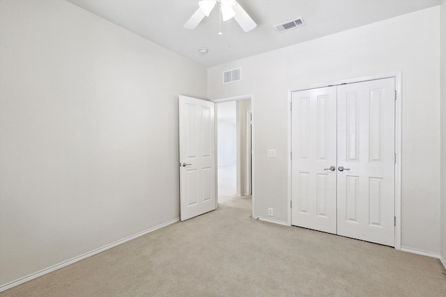 unfurnished bedroom with ceiling fan, a closet, and light carpet