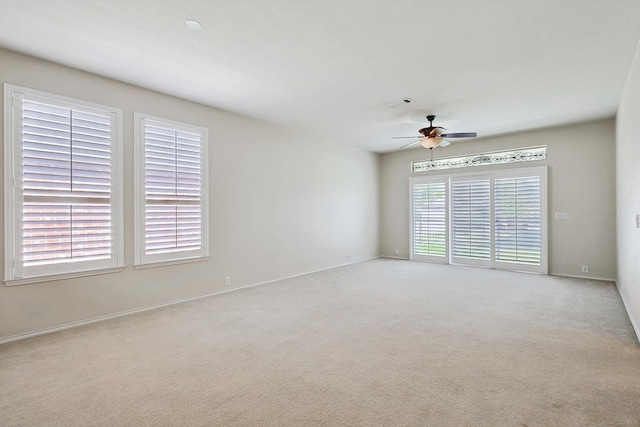 carpeted spare room with ceiling fan