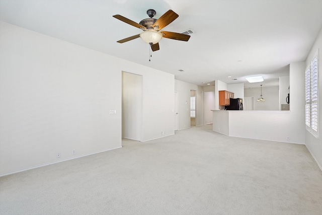 unfurnished living room featuring ceiling fan and light carpet