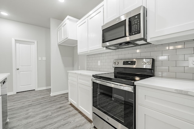 kitchen with light wood-type flooring, decorative backsplash, stainless steel appliances, and white cabinets