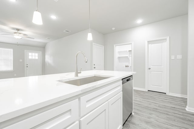 kitchen featuring hanging light fixtures, white cabinets, sink, and stainless steel dishwasher