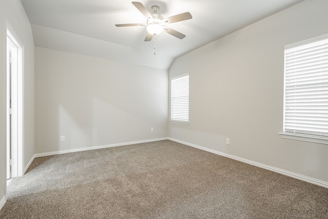 carpeted empty room featuring ceiling fan and vaulted ceiling