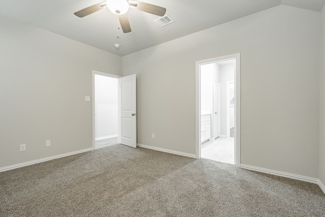 empty room with ceiling fan, light colored carpet, and vaulted ceiling