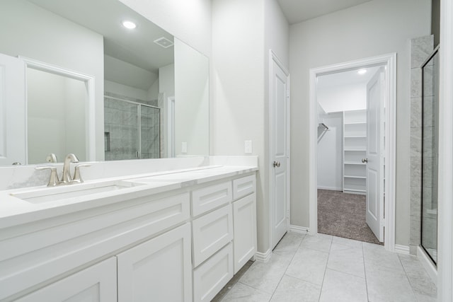 bathroom with tile patterned floors, walk in shower, and vanity