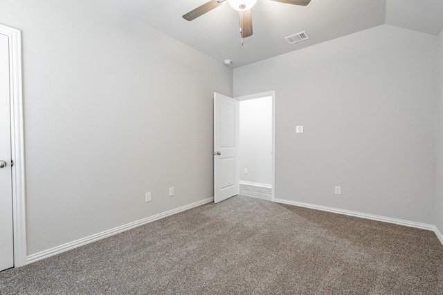 carpeted spare room featuring vaulted ceiling and ceiling fan