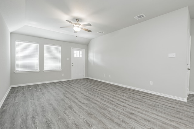 empty room featuring lofted ceiling, light hardwood / wood-style floors, and ceiling fan