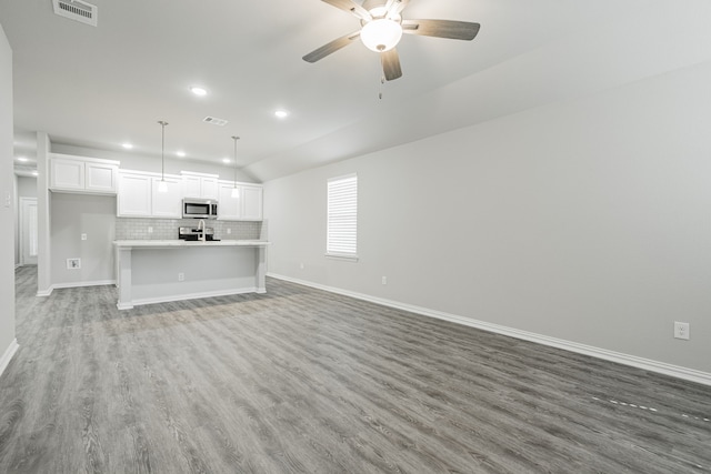 unfurnished living room featuring ceiling fan, lofted ceiling, and hardwood / wood-style floors