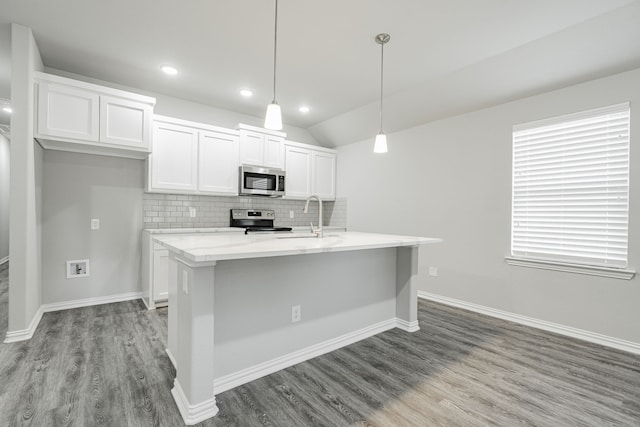 kitchen with pendant lighting, a center island with sink, stainless steel appliances, and white cabinetry