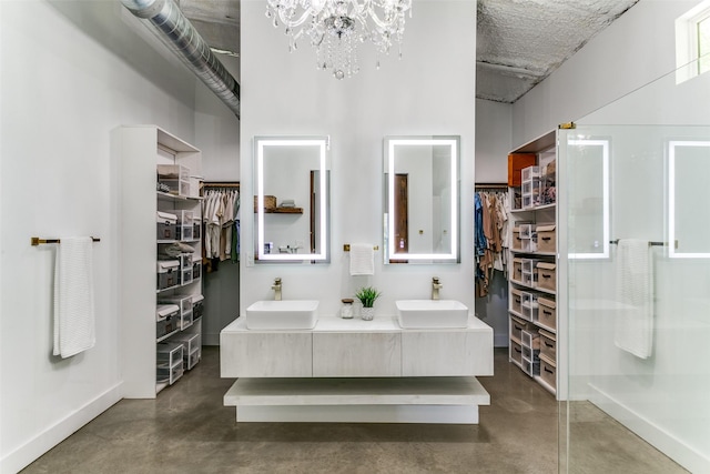 full bath with a sink, a walk in closet, and finished concrete flooring