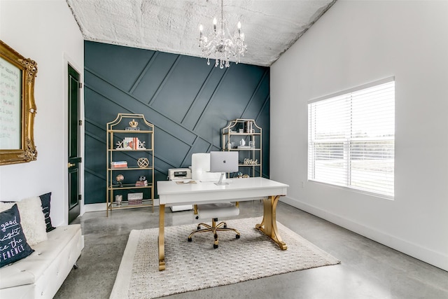 home office with baseboards, an inviting chandelier, and finished concrete floors