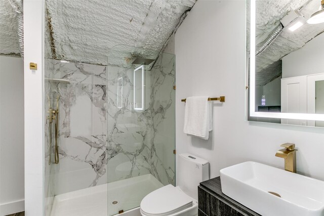 full bathroom featuring vanity, toilet, and a marble finish shower