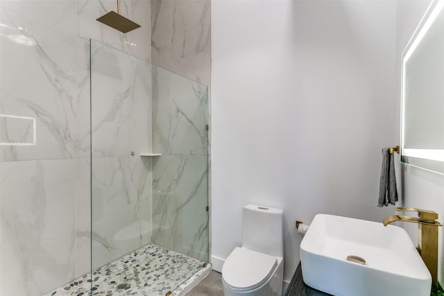 full bath featuring a marble finish shower, toilet, and a sink