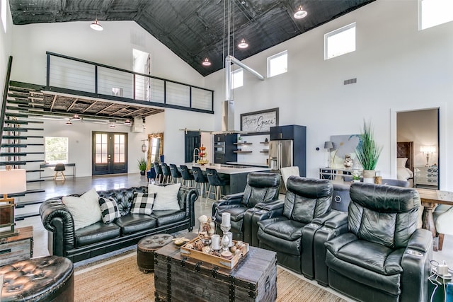 living area featuring french doors, visible vents, and a towering ceiling