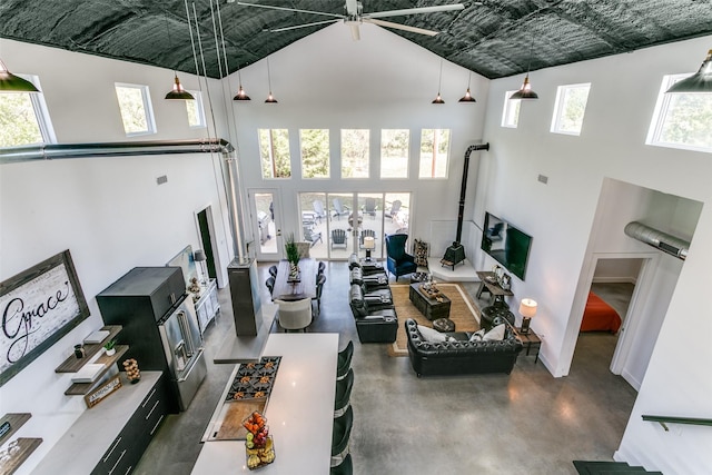 living area with a wealth of natural light, a high ceiling, and concrete flooring