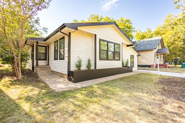 view of property exterior featuring a lawn and a patio area