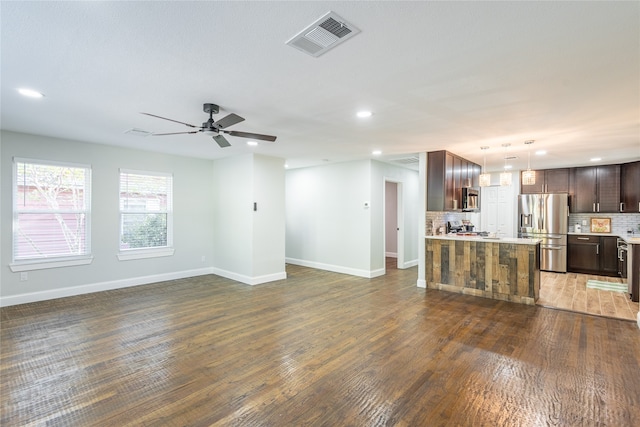 unfurnished living room featuring ceiling fan and dark hardwood / wood-style flooring