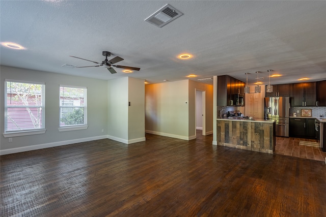 unfurnished living room featuring a textured ceiling, ceiling fan, and dark hardwood / wood-style flooring