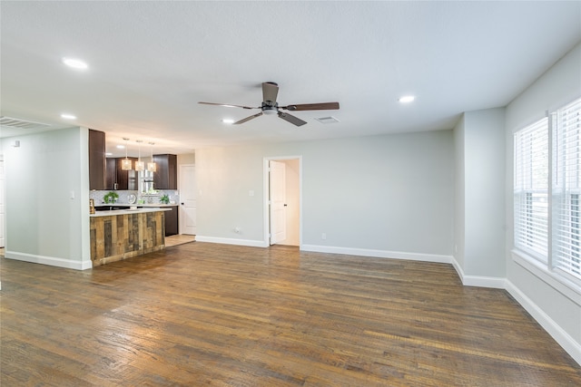 unfurnished living room with ceiling fan and dark hardwood / wood-style flooring