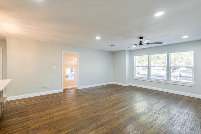 unfurnished living room featuring dark wood-type flooring, plenty of natural light, and ceiling fan