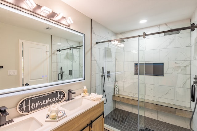 bathroom featuring a shower with door and vanity