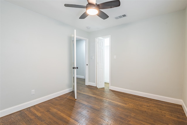 empty room featuring ceiling fan and dark wood-type flooring