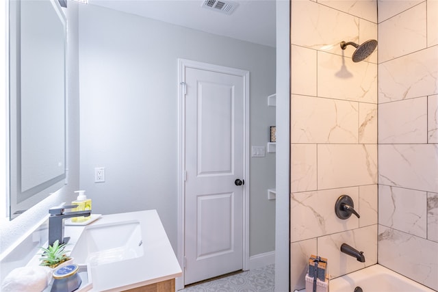 bathroom featuring vanity and tiled shower / bath