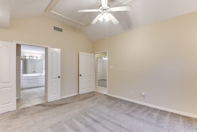 unfurnished bedroom with ceiling fan, light colored carpet, lofted ceiling, and connected bathroom